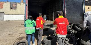 Foto que muestra personas recolectando llantas en desuso