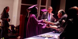 Foto de una de las graduandas recibiendo su diploma