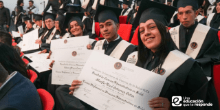 Imagen de estudiantes alzando sus diplomas de grado