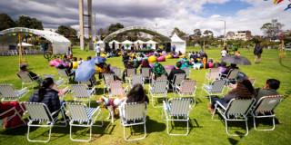 Foto que muestra personas sentadas en sillas en un parque