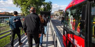 Foto de personas junto a un bus de TransMilenio