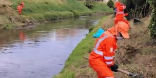 Foto que muestra trabajadores limpiando un canal de Bogotá