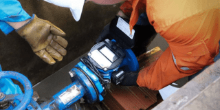 Imagen de un técnico de la empresa de Acueducto realizando mantenimiento en un tubo de alcantarillado.