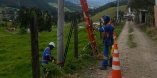 Imagén de técnicos de ENEL realizando mantenimiento en postes ubicados en zona rural