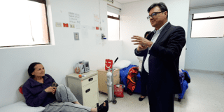 Foto del secretario de Salud hablando con una paciente 