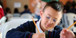 Niño escribiendo con lápiz 