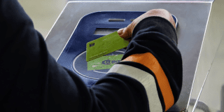 Imagen de una persona pasando la tarjeta TuLlave en un torniquete de TransMilenio