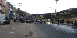 Imagen de varias personas bloqueando el paso de un bus del SITP