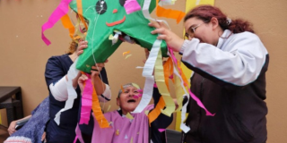 Imagen de una persona mayor sonriendo junto con otras dos personas