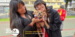 Foto de un perrito junto a sus dos dueñas