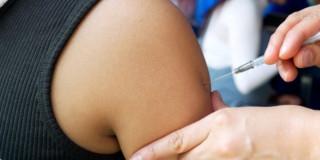 Foto que muestra una enfermera colocando una vacuna 