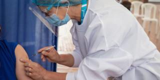 Foto que muestra una enfermera colocando una vacuna 