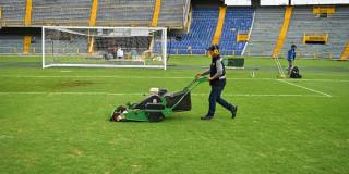 Foto de trabajos y operarios en la gramilla del estadio El Campín de Bogotá.