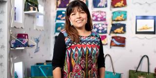 Foto de una mujer comerciante y su negocio de productos de cuero.