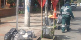 Foto que muestra bolsas de basura y un trabajador de la UAESP