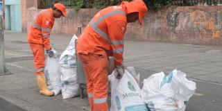 Foto que muestra dos personas recogiendo residuos en la calle 