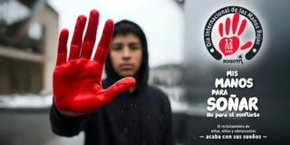 Niño mostrando el símbolo de la mano roja con su mano.