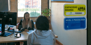 Imagen de una funcionaria atendiendo a una mujer