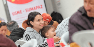 Imagen de una madre con su hijo dándole comida