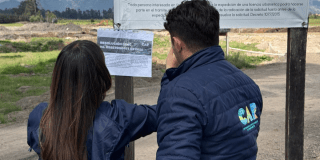 Imagen de dos personas de la CAR sellando el predio