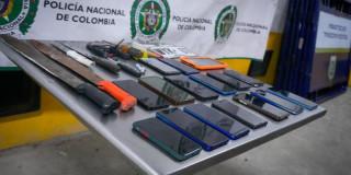 Foto que muestra celulares y armas sobre una mesa