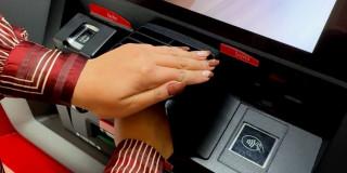 Mano de mujer retirando dinero de un cajero automático