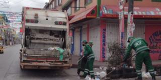 foto que muestra un camión recolector de basura y trabajadores de la UAESP