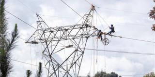 Foto que muestra una antena de energía y trabajadores de Enel Colombia