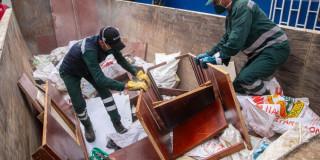 Foto que muestra dos personas recogiendo residuos 