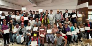 Foto que muestra un grupo de personas sonriendo y con un diploma en la mano