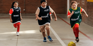 Imagen de tres niños jugando fútbol