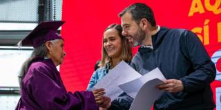 El alcalde Carlos Fernando Galán entregando un diploma a una mujer
