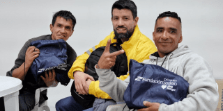 Imagen de tres personas con sus kits escolares