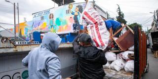 Foto que muestra una persona dejando una bolsa en un ecopunto
