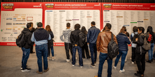 Imagen de varias personas viendo carteles con información de empleo