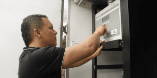 Imagen de una persona oprimiendo botones en un medidor de aire