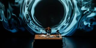 Imagen de Dj con consola y fondo de ondas sonoras en azul