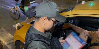 Uniformada de la policía verificando un taxi para el servicio