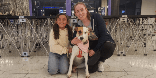 Imagen de una señora con una niña y una perrita recién adoptada