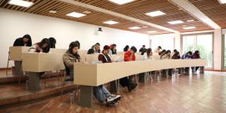 Foto que muestra estudiantes sentados en un salón 