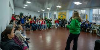 Foto que muestra un grupo de personas reunidas en un salón 