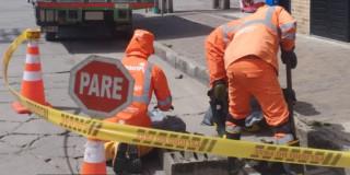 Foto que muestra trabajadores de Aguas Bogotá limpiando un sumidero