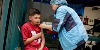Foto que muestra una enfermera colocando una vacuna a un niño 