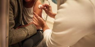 Foto que muestra una enfermera colocando una vacuna 