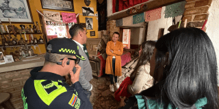 Foto de funcionarios del Distrito hablando con una ciudadana 