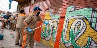 Foto de privados de la libertad durante la jornada de embellecimiento de fachadas de las 18 Plazas Distritales de Mercado en Bogotá.