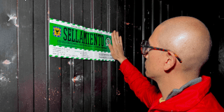 Imagen de un funcionario poniendo el letrero de sellamiento