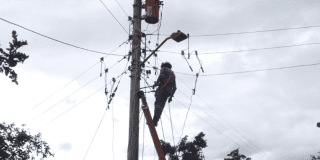 Imagen de un técnico de ENEL realizando mantenimiento en un poste de luz.
