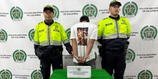 Hombre capturado por presunto homicidio, entre dos uniformados.