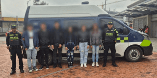 Imagen de los seis capturados y de fondo una patrulla de la Policía